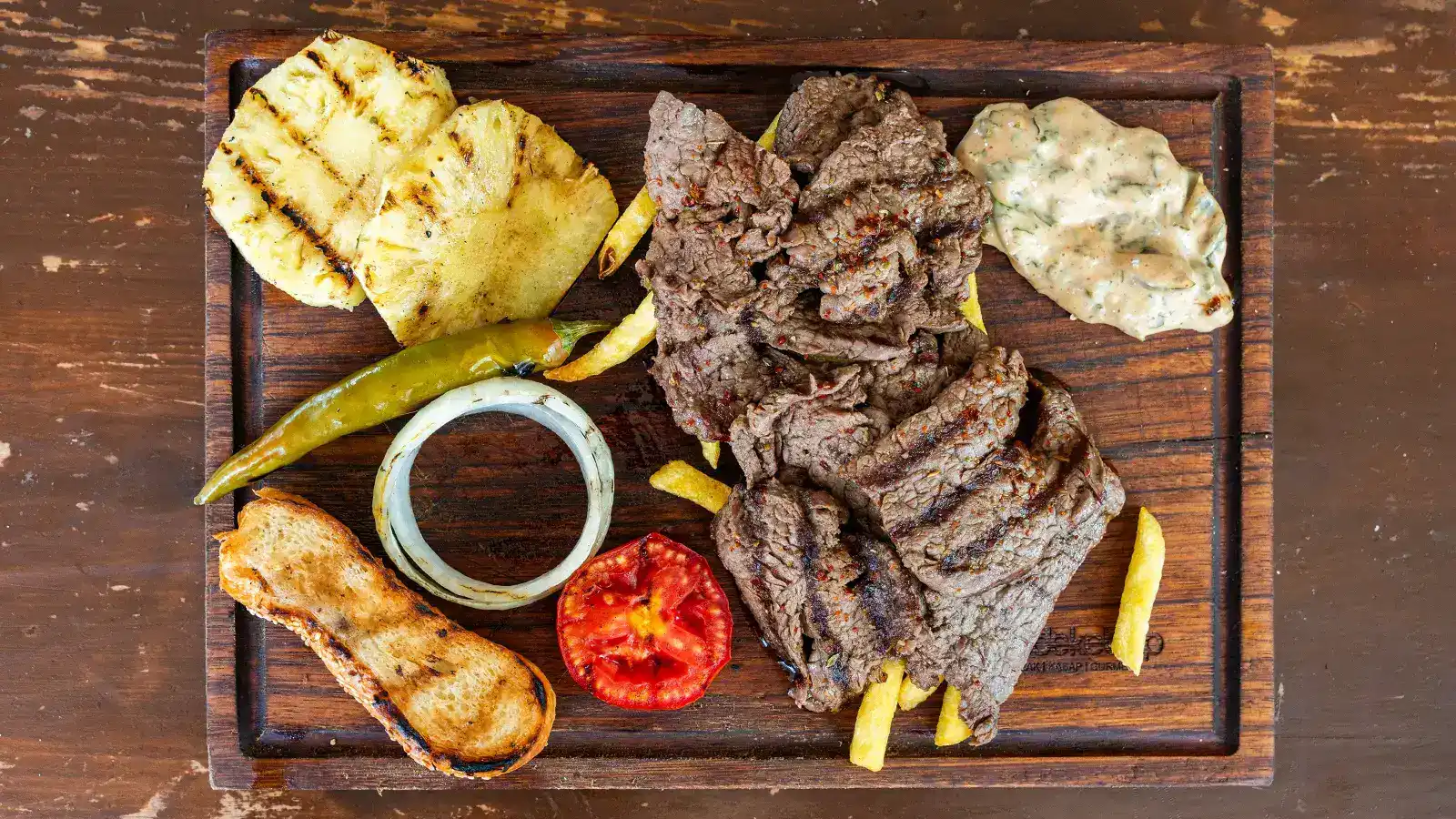 Yaprak steak porsiyonu, ince kesilmiş ızgara et tabağı közlenmiş sebzeler ve sos ile – Bakı Dede Kebap Steak Burger Tatlı Kasap