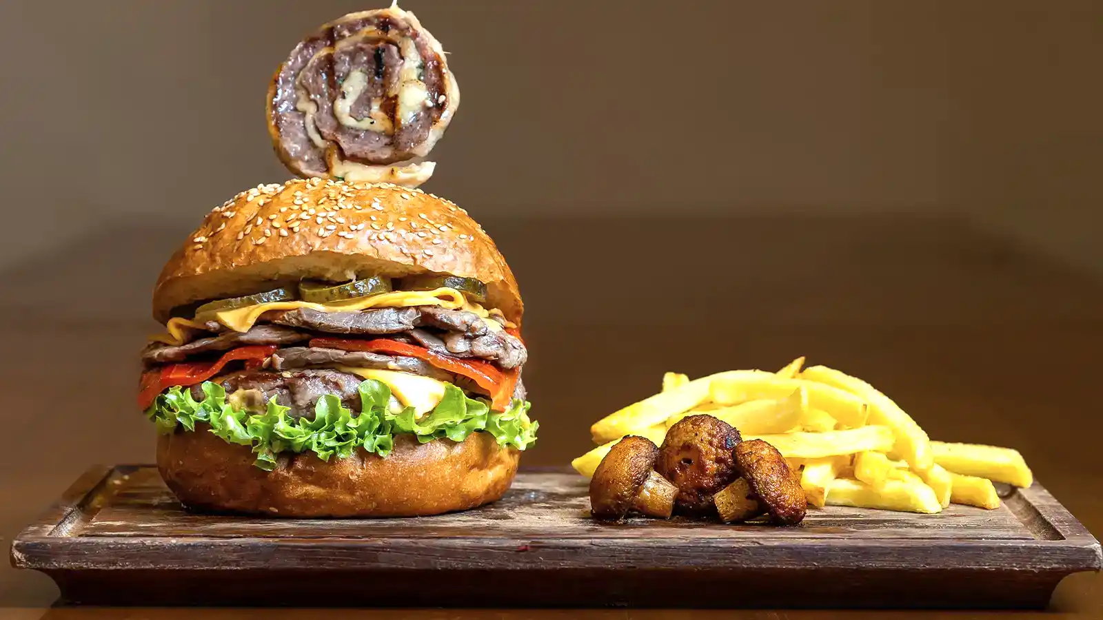 Ottoman Burger, cheddar peynirli ve ızgara et dilimli burger, yanında patates kızartması ve sos ile – Bakı Dede Kebap Steak Burger Tatlı Kasap